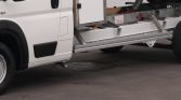 White delivery truck with a lowered side ramp or liftgate extended from the cargo area.