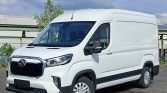 White cargo van parked outdoors, front-right three-quarter view, with black grille and side mirrors.