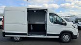 White cargo van with the side door open, exposing an empty cargo area inside.