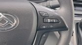 Close-up of a car steering wheel showing phone, volume, and SRC buttons on the right side, with airbag emblem nearby.