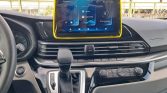 Car dashboard with a yellow-framed touch screen infotainment display located above the center console.