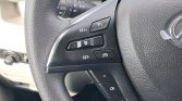 Close-up of a car steering wheel with cruise control buttons (RES+, SET-, cancel) on the left side, Lexus emblem visible on the right edge.