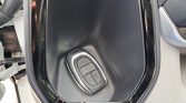 Car key fob resting in a recessed door pocket of a vehicle interior.
