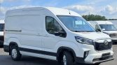 Front-left view of a white cargo van with raised roof and black grille, parked in a lot with other vans nearby.