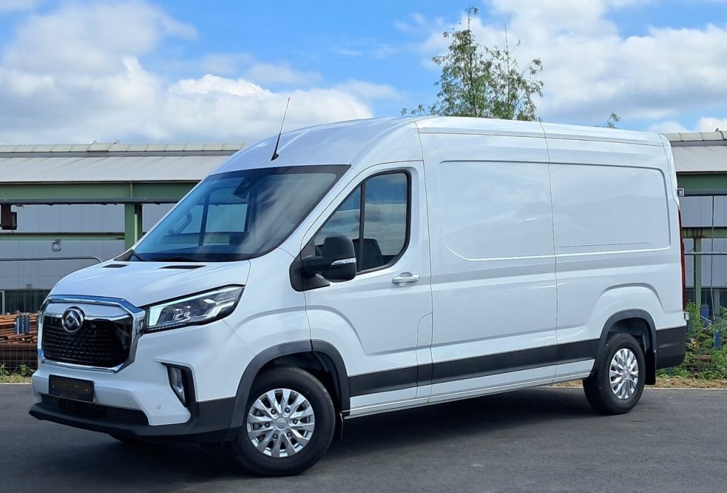 White cargo van parked outdoors, three-quarter front view with black bumper and grille detail, blue sky in the background