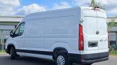 White cargo van parked in an outdoor lot, side and rear views with closed rear doors and black bumper.