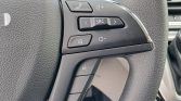 Close-up of a car steering wheel with audio/phone controls (SRC, volume, mute, and call buttons).