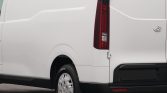 Rear side of a white cargo van with vertical taillight and wheel, seen from behind.