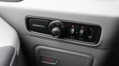 Car interior door panel with a circular mirror-adjustment knob labeled L and R, plus small control toggles and a USB port on the panel.