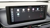 Infotainment touchscreen in a car showing app icons: Apple CarPlay, Android Auto, Radio, Albums, Gebruikershandleiding, with a left vertical menu.