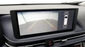 In-car rearview camera screen showing parking guidelines and safety alert for backing up with sensor cues on the right side.