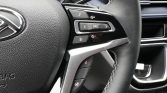 Close-up of a car steering wheel with multimedia controls (SRC, volume, phone) on the right side and stitched grip edge.