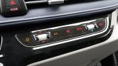 Car dashboard climate controls: illuminated A/C, left power button, central fan sliders, red defrost indicator, and MODE knob on the right trim panel.