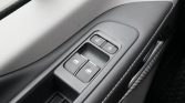 Close-up of a car's driver-side door controls: window switches and lock/unlock buttons on a black panel