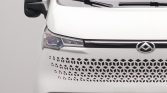 Front view of a white van with a honeycomb-pattern grille and chrome emblem on the hood area