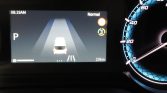 In-dash parking assist screen: top-down view of the white car centered on lane markings, gear in P, time 08:19 AM, 23 km range left