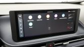 Infotainment touchscreen in a car showing apps (Apple CarPlay, Android Auto, Radio, Albums) and a left-side control rail on a dark display panel.