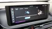 Wide car infotainment touchscreen in dashboard displaying Bluetooth setup prompts in Dutch, with climate/vehicle icons on the sides.