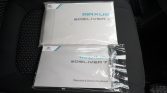 Two Maxus eDELIVER 7 manuals in plastic on a car seat, with a warranty & service handbook visible