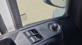 Car door interior panel with window switches and mirror adjustment knob.