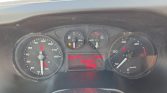 Car instrument cluster: left speedometer up to 190 km/h, right tachometer, central red digital display with text, and warning lights active.