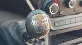 Manual gear shift knob with shift pattern R, 1–6 in a car interior, dashboard climate controls in the background