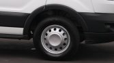 Close-up of a silver steel wheel with hubcap on a white van