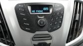 Car stereo control panel with blue display reading 'NO PHONE' and central volume knob surrounded by buttons on both sides.