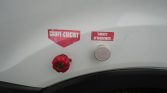 Red emergency circuit-breaker knob on a white surface with labels 'Coupe-Circuit' and 'Arrêt d'Urgence'.