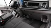 Interior of a vehicle: driver’s seat, passenger seat, and dashboard with a large touchscreen infotainment display.