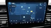 In-car touchscreen showing a navigation map with route, blue pins, and map details.