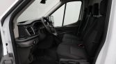 Front cargo van cabin: driver seat, two passenger seats, steering wheel, and dashboard visible inside a white van