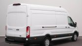 Rear three-quarter view of a white Ford Transit cargo van with double rear doors, parked indoors.