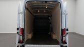 Open white cargo van with rear doors wide, empty loading space lined with plywood panels and small wooden blocks on the floor