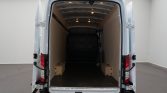 White cargo van with rear doors wide open, showing an empty wooden-paneled cargo area and dark floor.