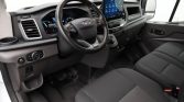Interior of a modern van cabin showing steering wheel, digital instrument cluster, and a large central touchscreen on the dashboard.