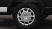 Car wheel with a silver hubcap and rugged tire on a black vehicle, parked on asphalt