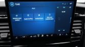 Car touchscreen displaying Apps menu with tiles: Mobile apps zoeken, Apple CarPlay, Android Auto, Help voor mobiele apps; climate controls and radio shown below and on the side.”