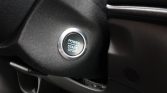 Push-start ignition button in a car, labeled Power Start Stop, with a chrome ring.