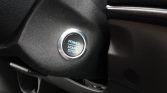 Push‑button ignition on a car dash labeled POWER START STOP, surrounded by a chrome ring near the steering column.