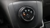 Circular car gear selector with P, R, N, D, L; orange indicator light near P, mounted on black console