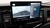 In-car display showing rearview camera with green/yellow/red parking guidelines and a top-down 360 view of the car.