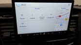 Infotainment screen in a car showing 'Functies' menu with Rijmodi, Toegang, Vertrek en comfort, Oplaadinstelling, Handleiding and a side map; time 08:52.
