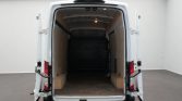 Open rear doors of white cargo van showing empty plywood-lined interior and black bulkhead.