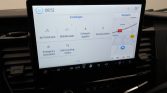 Car infotainment touchscreen showing Settings menu with options: Wi‑Fi Hotspot, Mobile apps, Software updates, Ford Assistant, Emergency Assistance, Valet parking mode; map panel on the right.