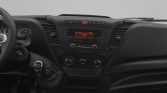 Interior of a car dashboard: steering wheel on left, manual gear shift, central console with orange display and climate controls