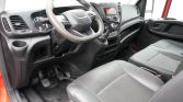 Interior of a vehicle cabin showing the steering wheel, dashboard, and front seats from the passenger side view