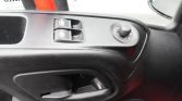 Driver-side car door panel with window controls and rounded mirror adjustment knob