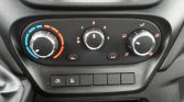 Dashboard climate control: left temperature dial from cool blue to warm red, center fan speed dial (0–4), right direction dial with vent icons; A/C button and additional function buttons below.