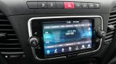 In-car infotainment touchscreen showing radio UI with station 107.10 MHz OSR 920 and navigation icons below the screen